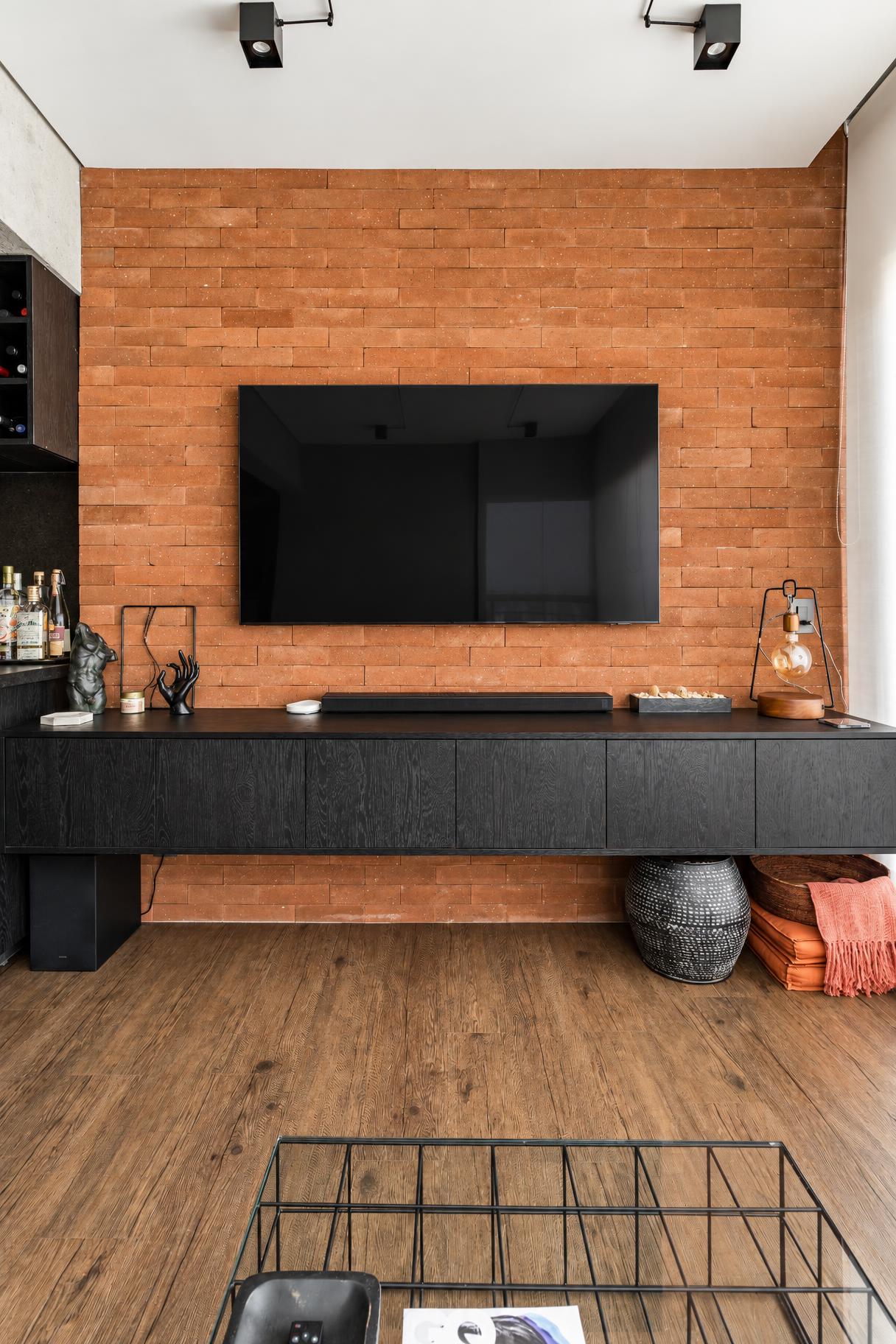 Sala de estar com painel de TV e rack em madeira clara